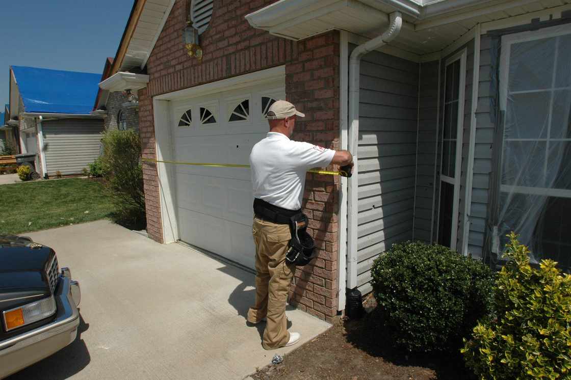 An insurance professional inspecting a storm-damaged property